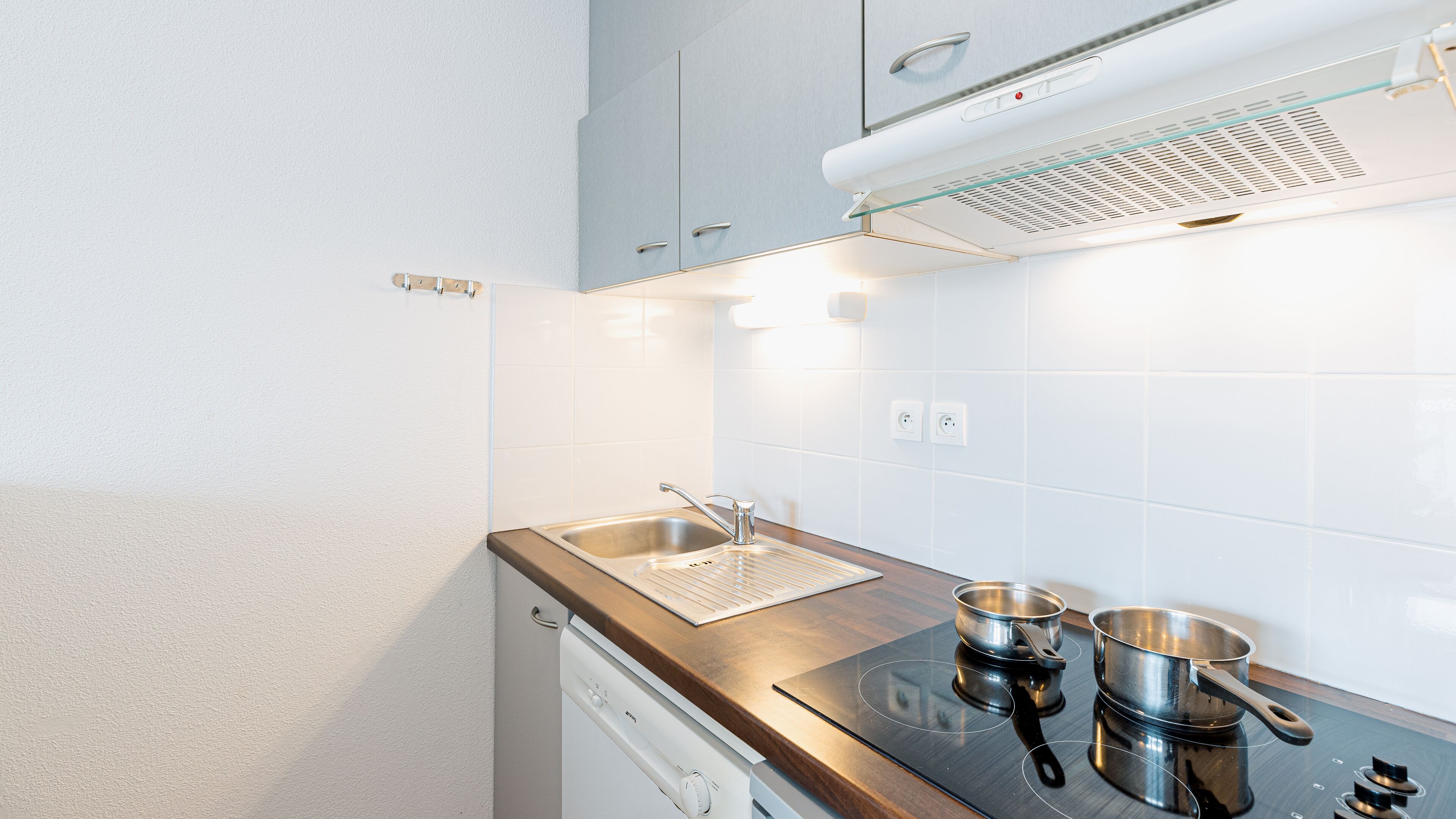 A modern kitchen with a stainless steel sink, a built-in oven, and a stove.
