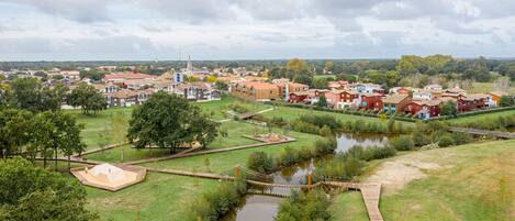 Un barrio residencial con casas, un río pequeño y un puente.