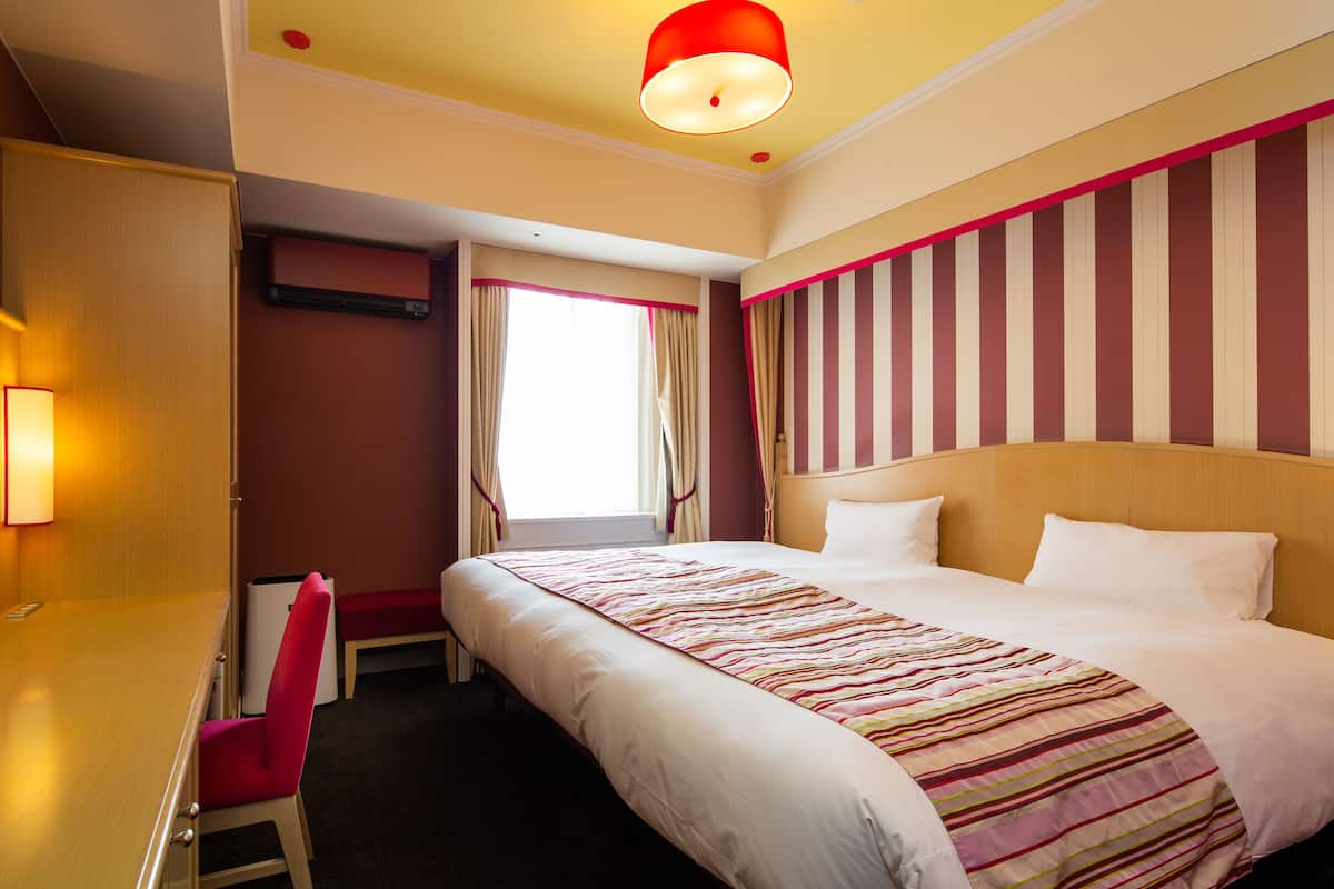 Ein Hotelzimmer mit einem großen Bett, einem Schreibtisch und einem Sessel.
