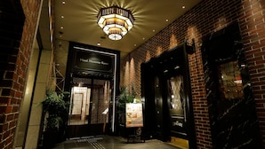 L'ingresso di un hotel con interni moderni, un lampadario importante e un cartello con la scritta Hotel Monterrey Kyoto.