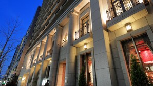 Facciata di un hotel con ampie colonne, balconi e insegne illuminate.