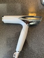 Un aspirapolvere bianco con ugello metallico e un manico.