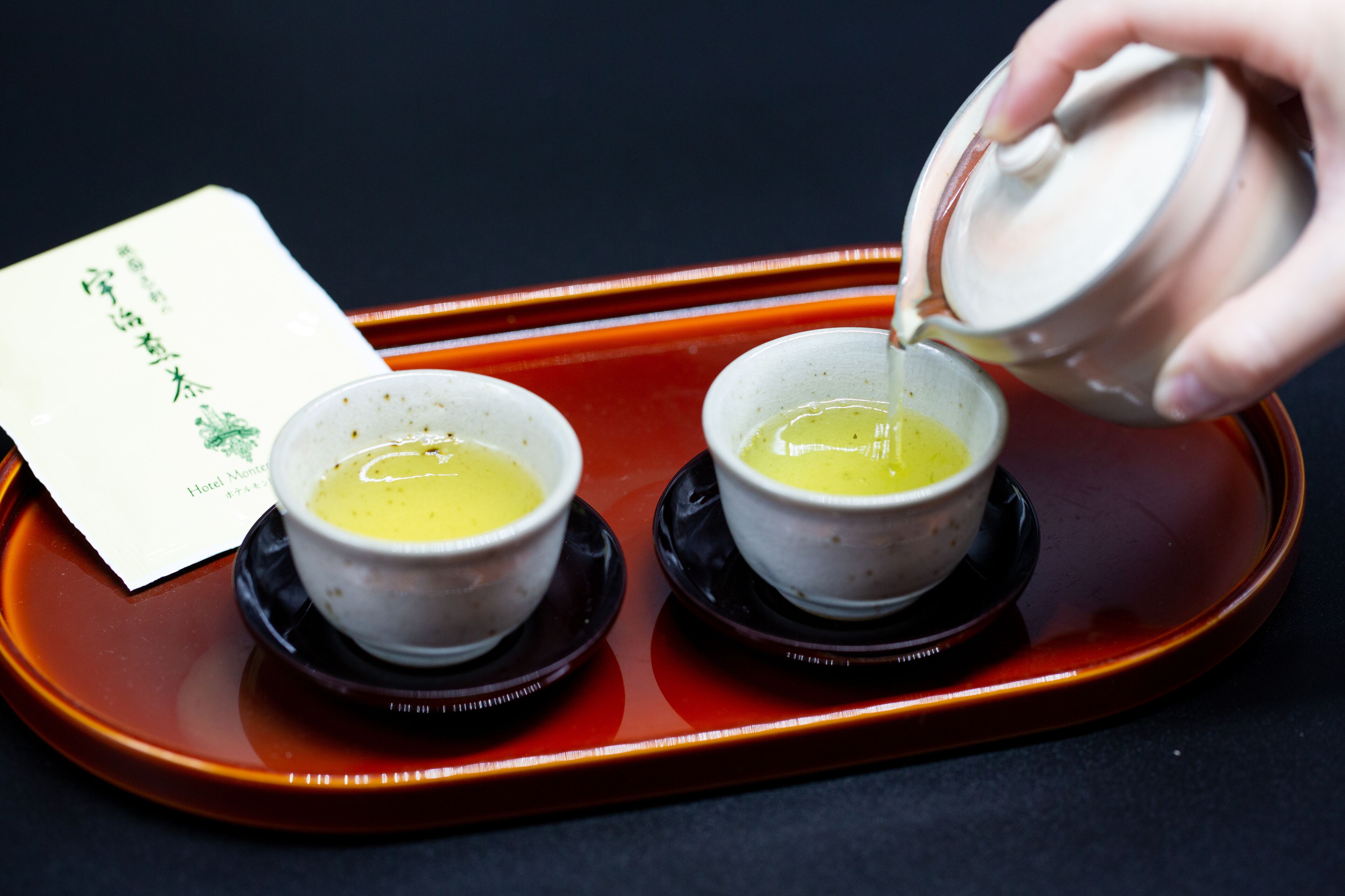 Two bowls of soup on a tray with a card beside them.