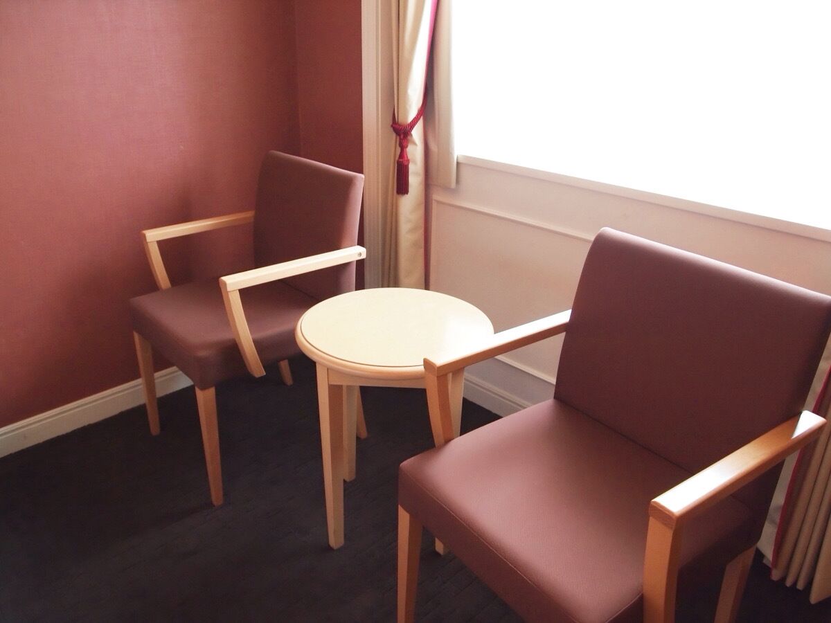 A room with two wooden chairs and a small round table.