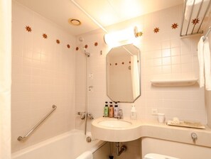 A bathroom with a bathtub, a shower, a sink with toiletries, and a mirror. - Hotel Monterey Nagasaki (Nagasaki)