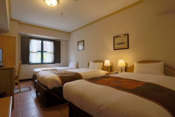 Une chambre d’hôtel avec deux lits, un bureau, une chaise, une fenêtre avec des rideaux et un tableau encadré au mur.