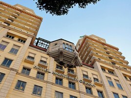 Um hotel de vários andares com varandas e uma placa chamativa com a inscrição 