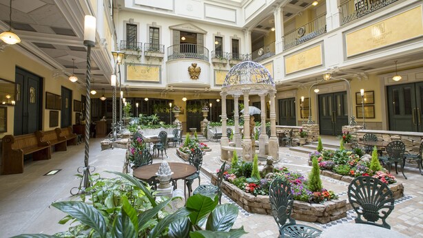 A spacious atrium with multiple levels, ornate columns, and a central fountain surrounded by seating areas and potted plants. - Hotel Monterey Sapporo (Sapporo)