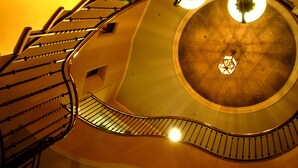 A spiral staircase with a circular ceiling and two chandeliers. - Hotel Monterey Sapporo (Sapporo)