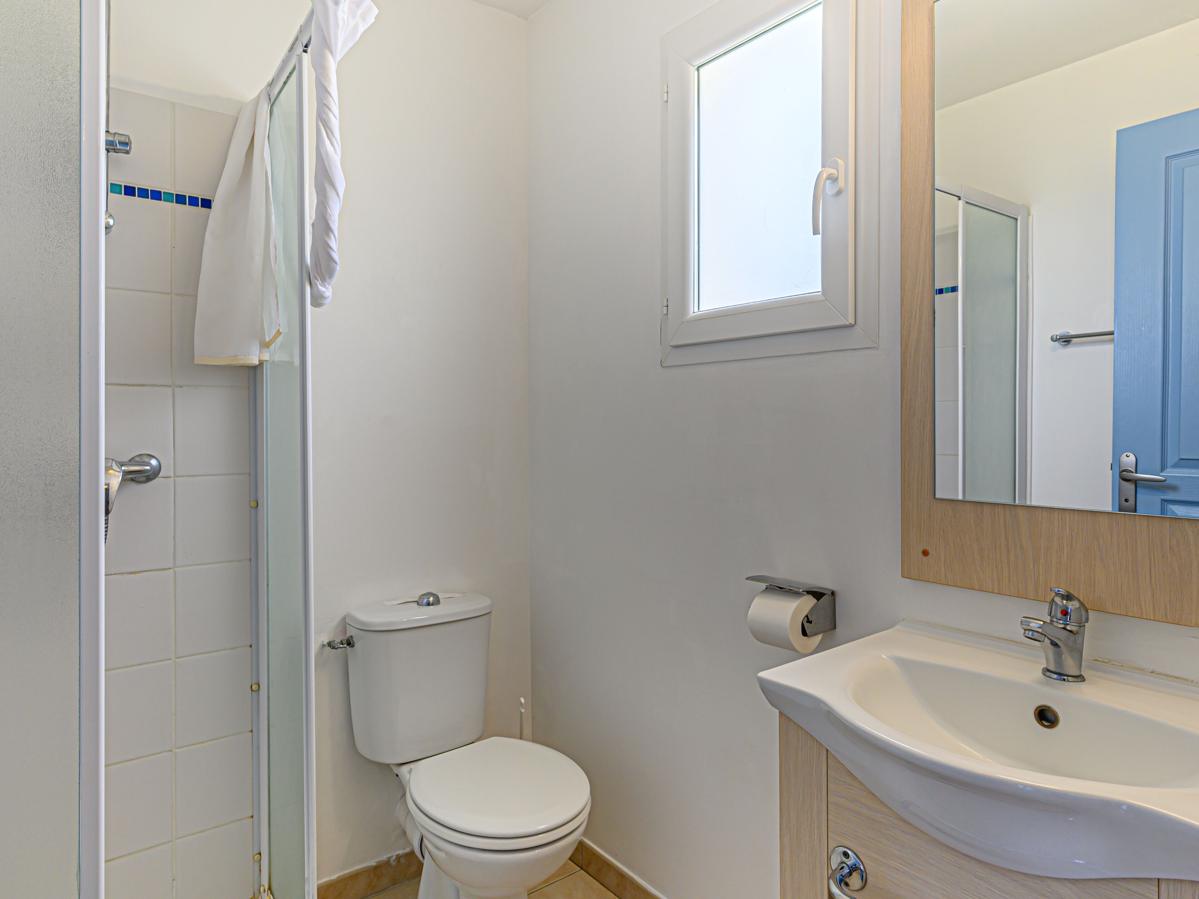 A bathroom with a toilet, sink, and shower.