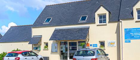 A building with a sloped roof and a sign indicating it is a reception area.