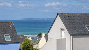 Un área residencial costera con casas de tejados a dos aguas y vista al mar.