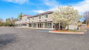 A two-story building with a parking lot in front.