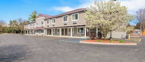 A two-story building with a parking lot in front.