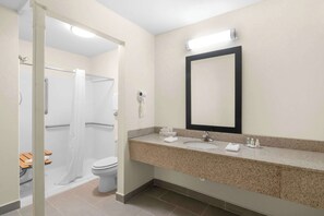 A modern bathroom with a shower, toilet, and sink.