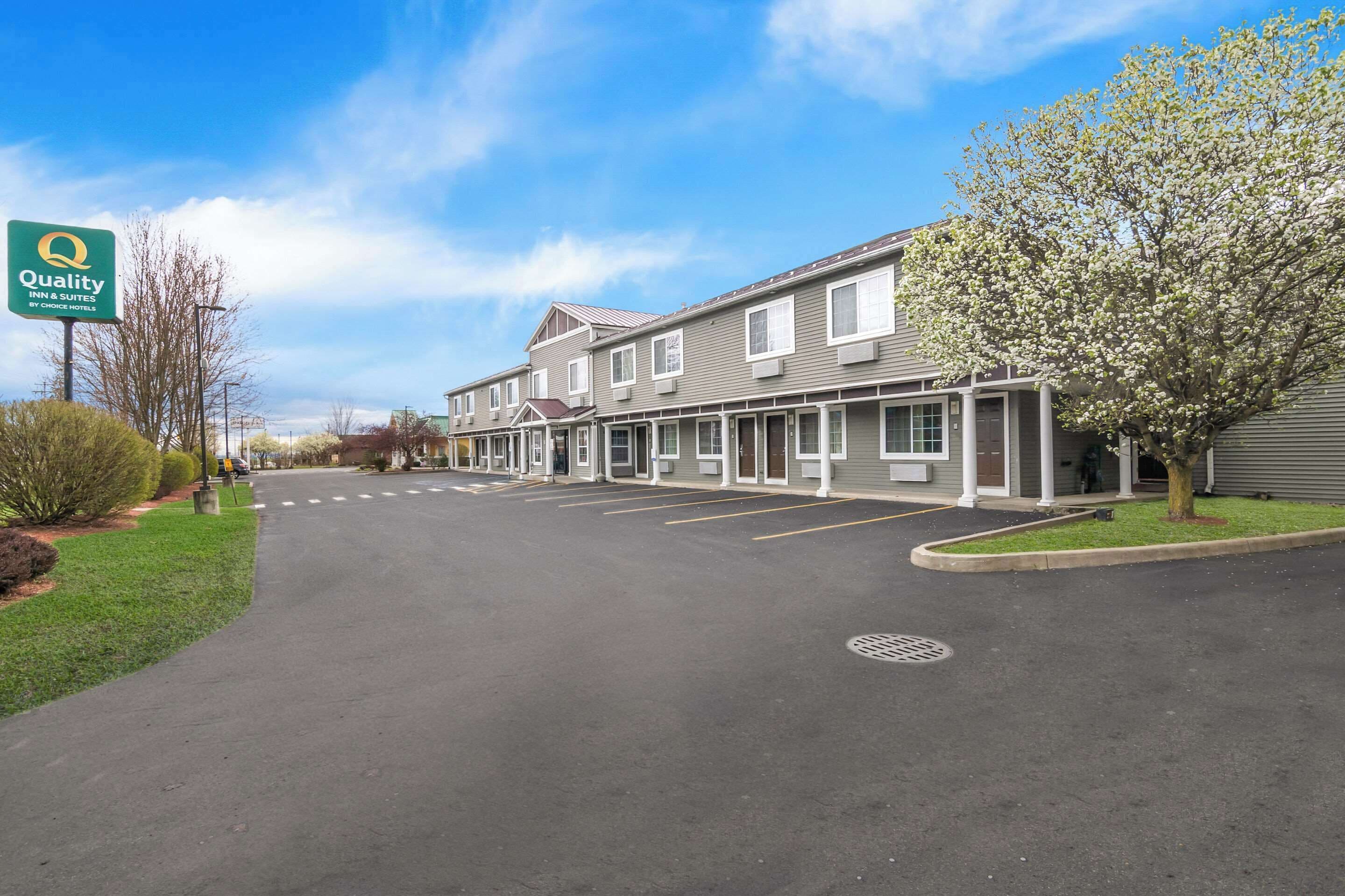 A Quality Inn & Suites by Econo Hotels with a parking lot and a row of single-story buildings.
