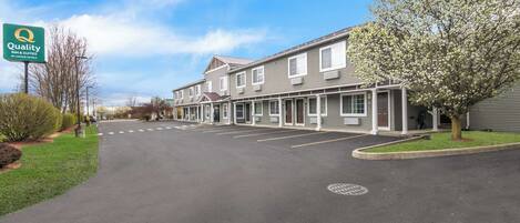 A Quality Inn & Suites by Econo Hotels with a parking lot and a row of single-story buildings.