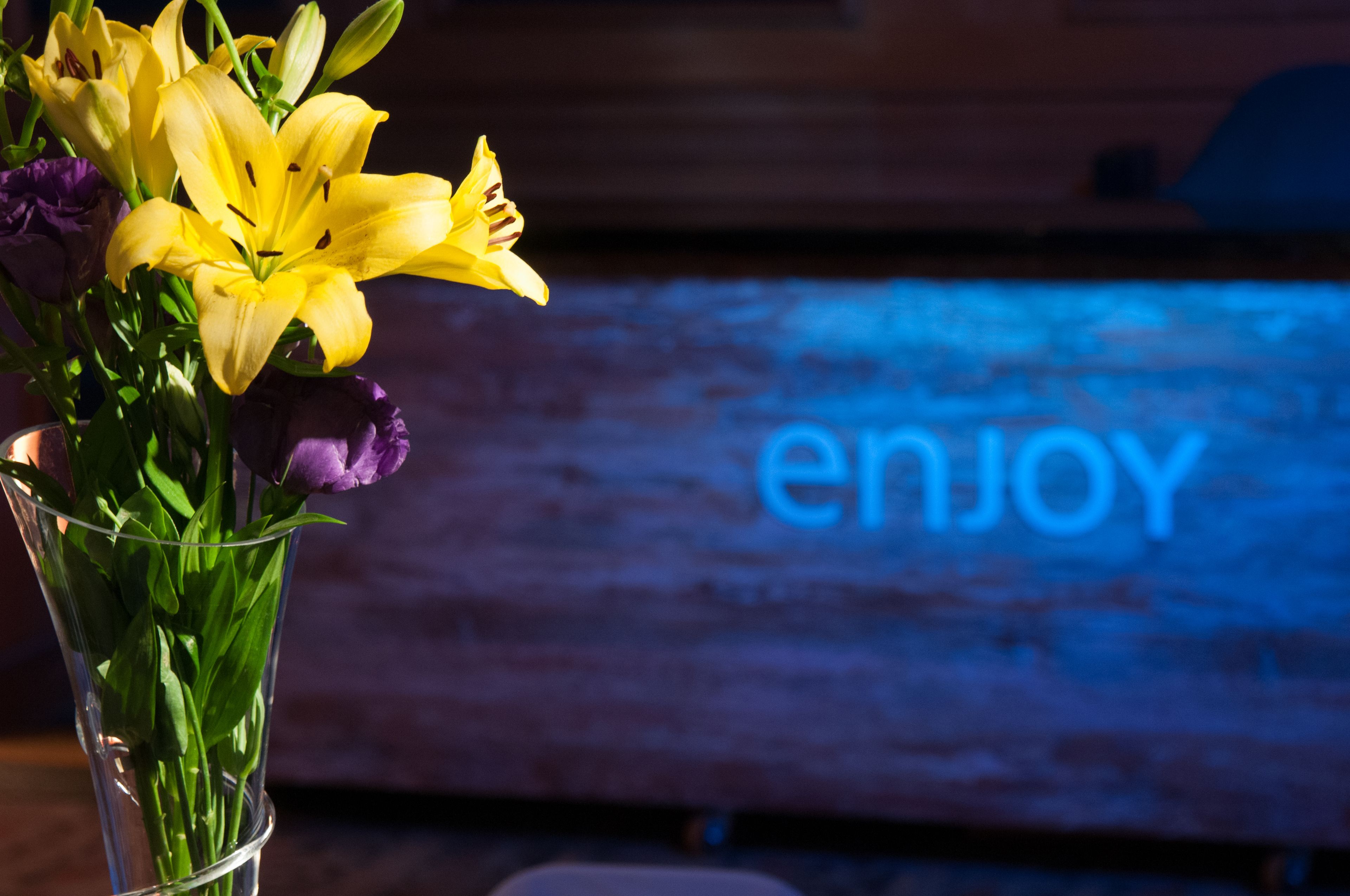 A bouquet of yellow and purple flowers in a clear glass vase.