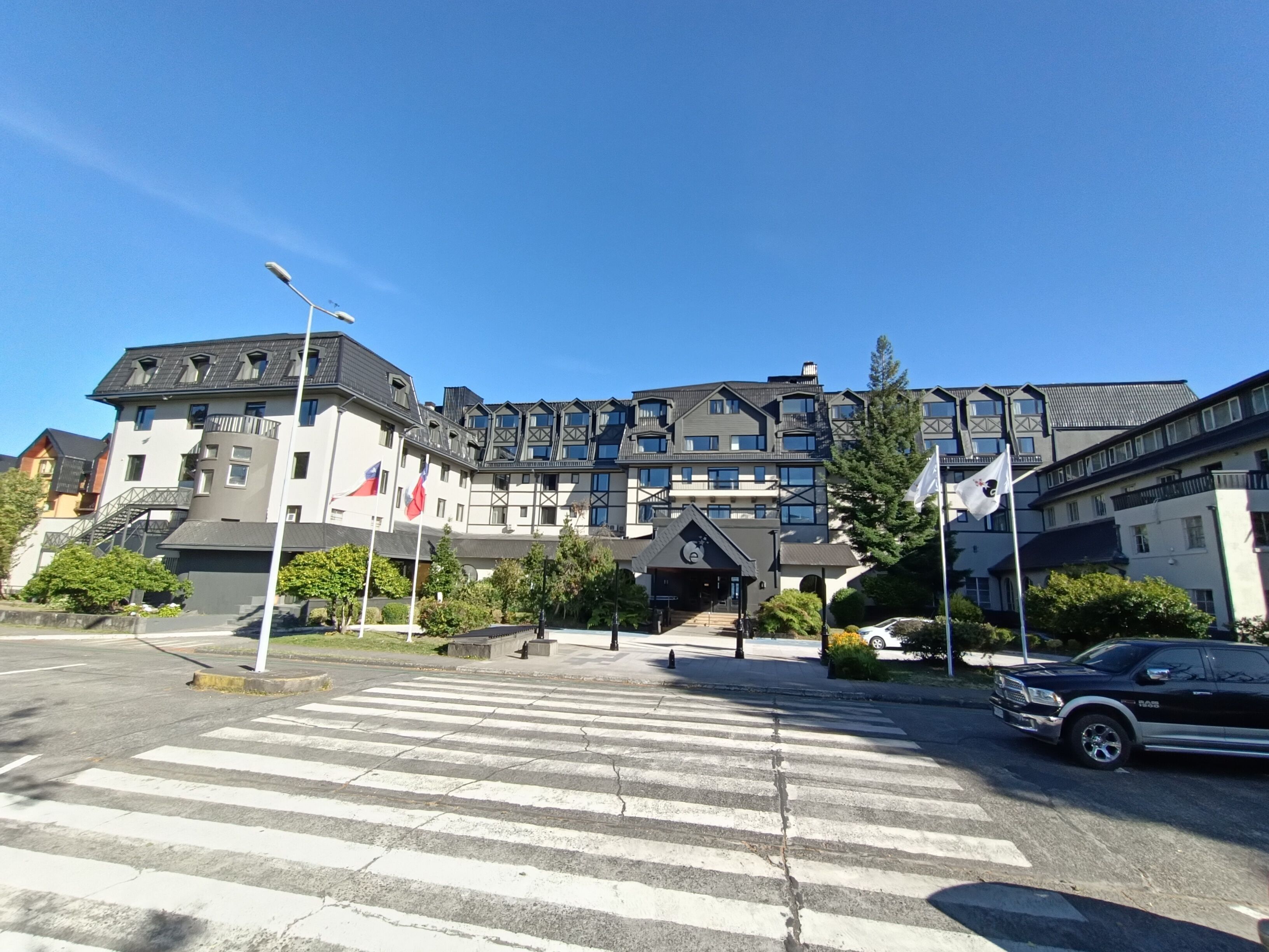 A multi-story hotel with a modern architectural design, featuring balconies and a central entrance.