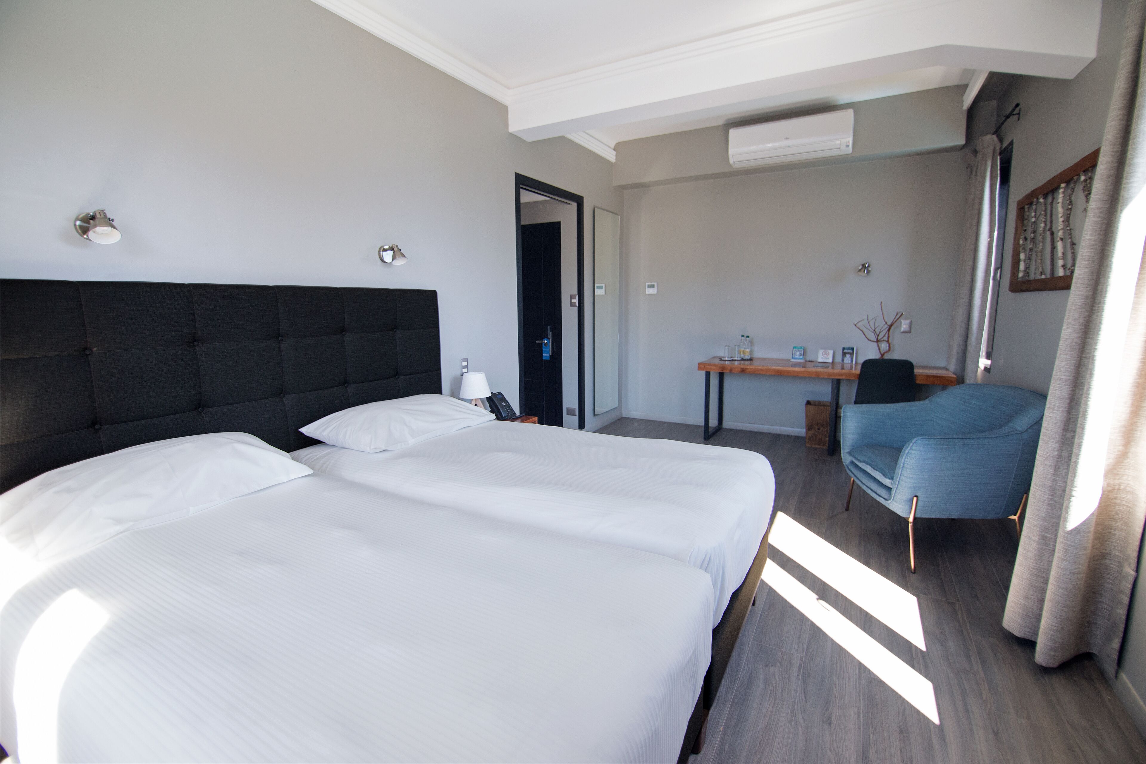 A hotel room with a large bed, a desk, and a chair.