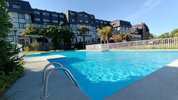 Relax by the pool surrounded by lush greenery and a serene atmosphere.