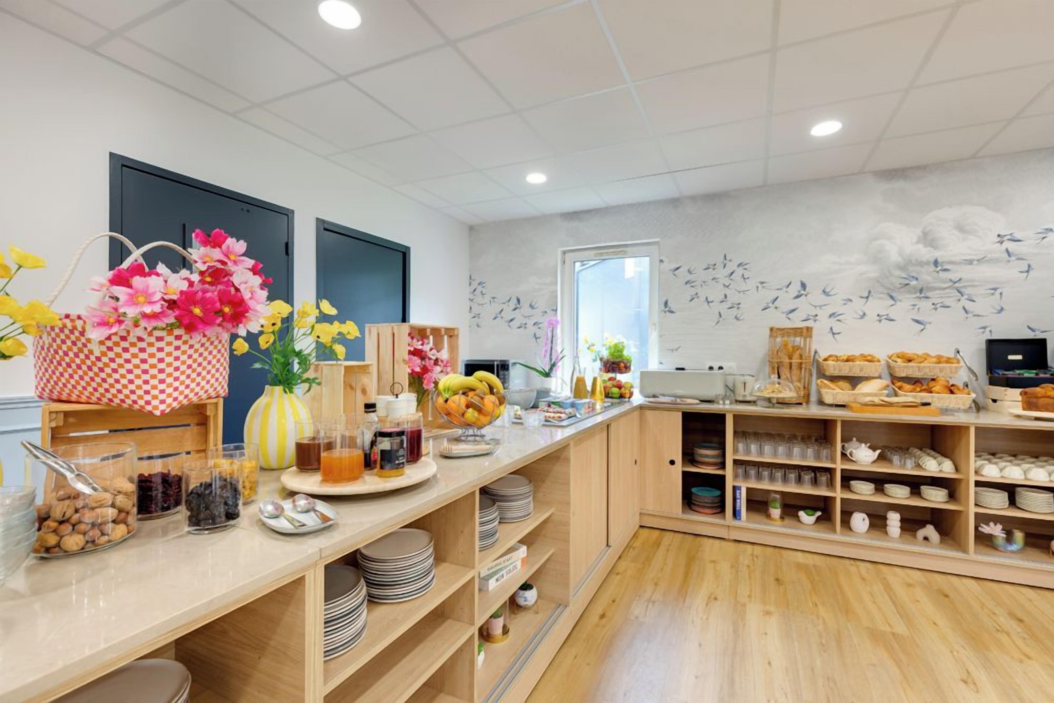 A breakfast buffet with various food items and a decorative wall mural.
