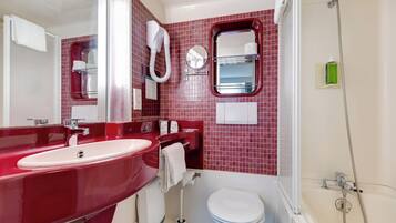 A bathroom with a red sink, white toilet, and a shower area.