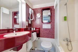 A bathroom with a red sink, white toilet, and a shower area.