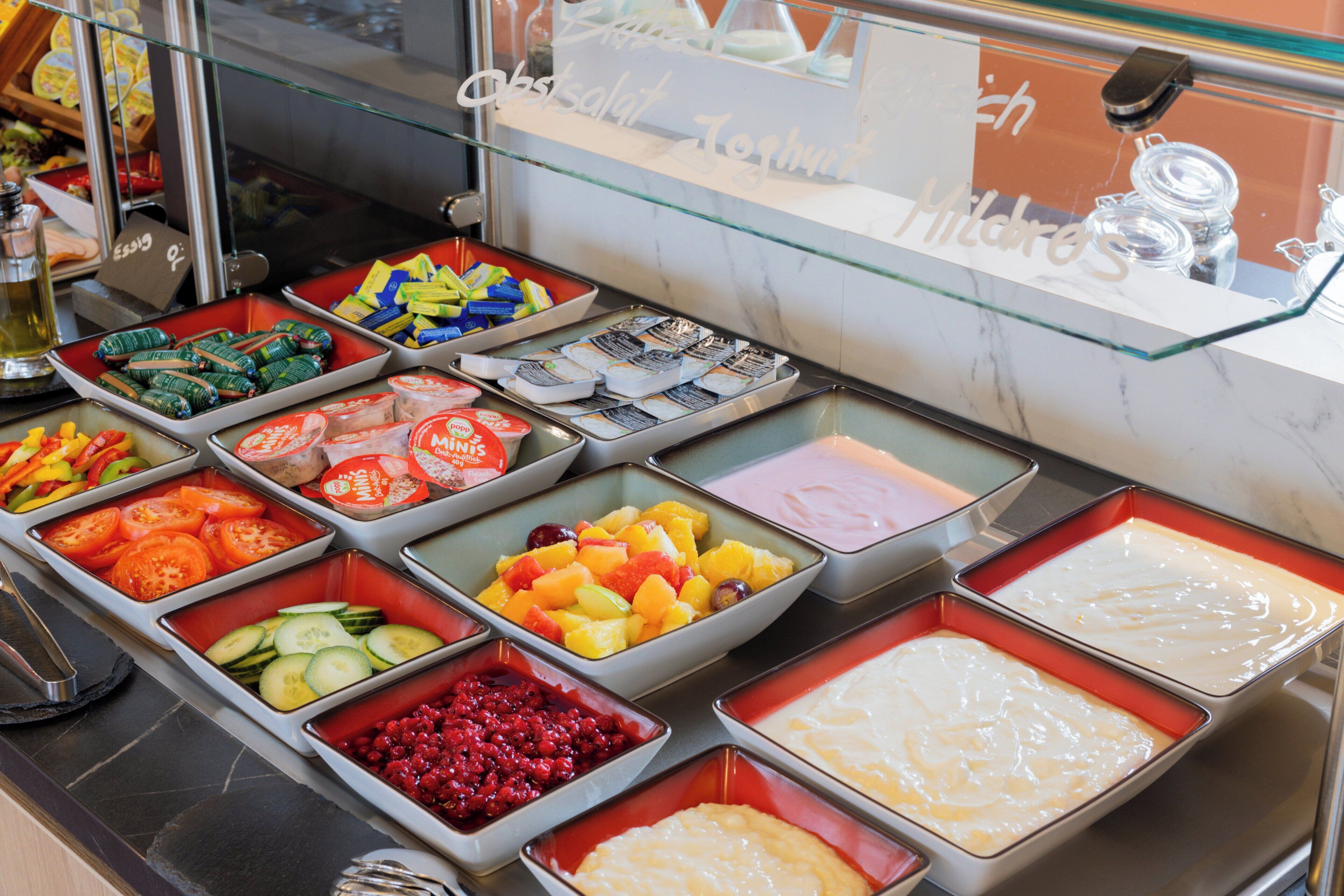 A buffet with various food items including fruits, vegetables, and desserts.