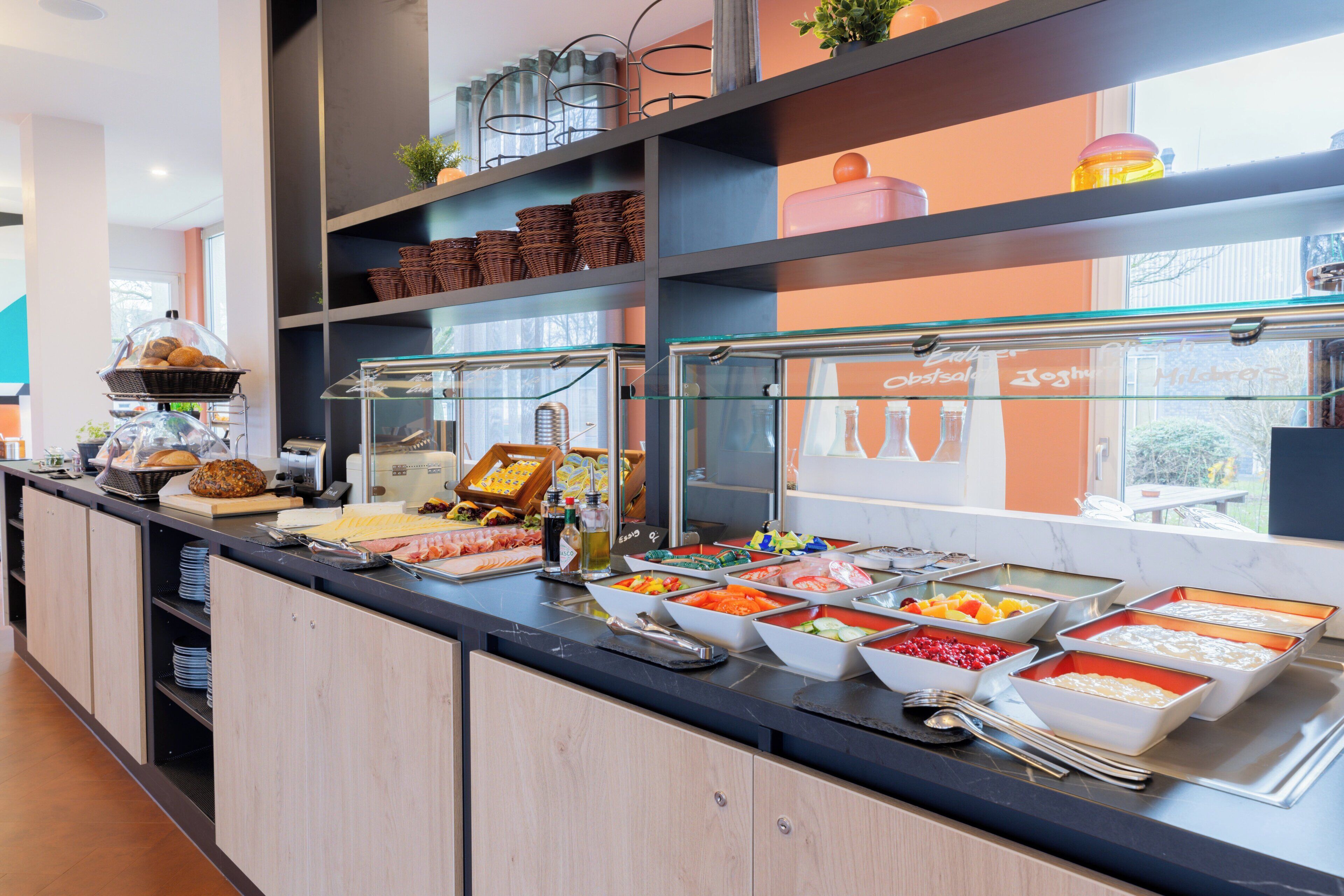 Ein Buffet mit verschiedenen Speisen und einer Glaskühltruhe.