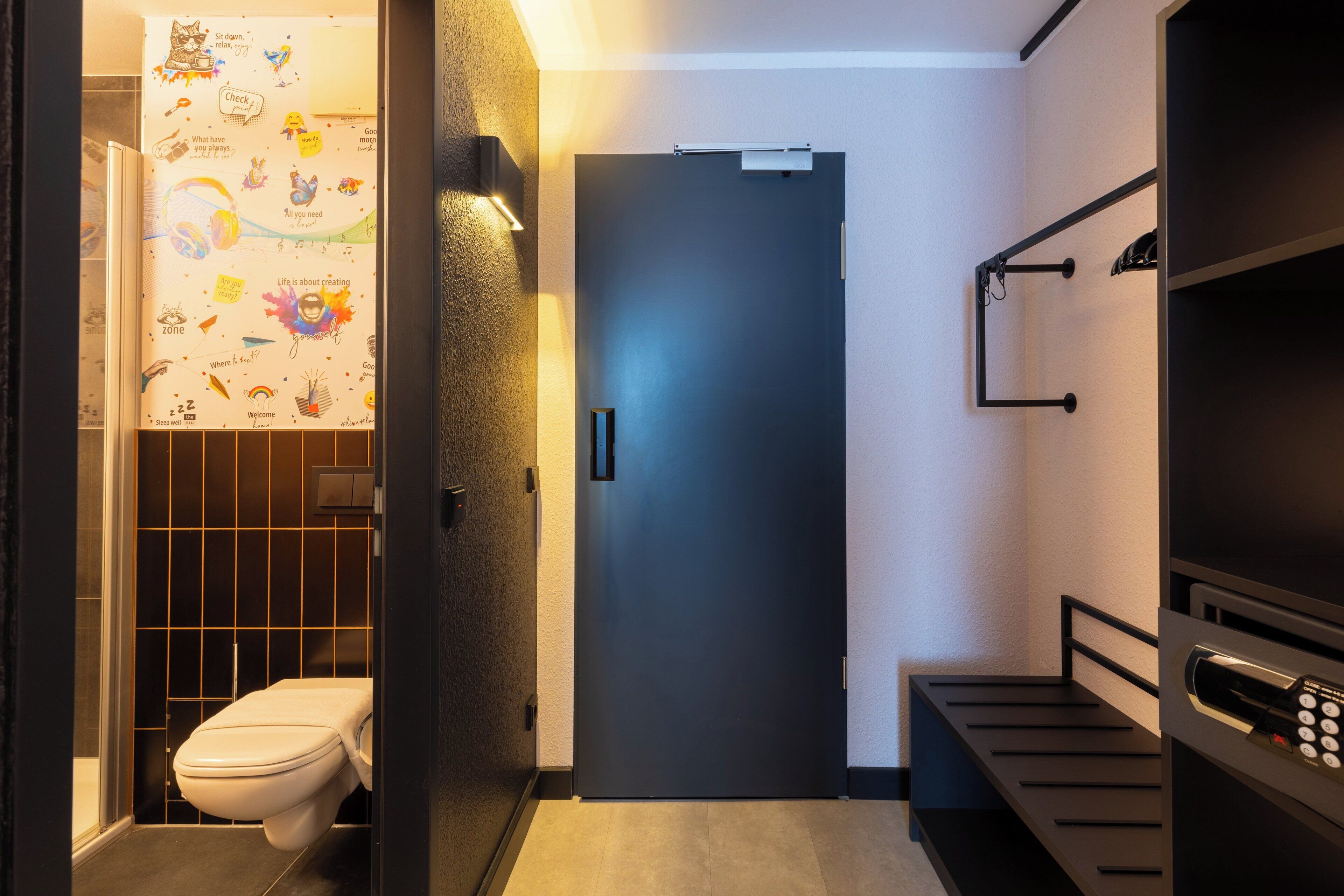 Een moderne badkamer met toilet, handdoekhouder en douche.