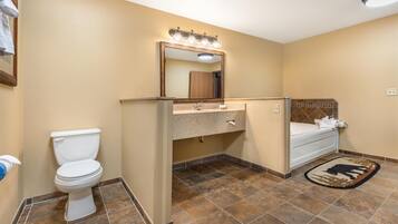 A bathroom with a toilet, sink, mirror, and a rug with a buffalo design.