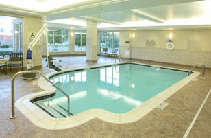 A swimming pool with a tiled edge, a lifeguard chair, and a no diving sign.