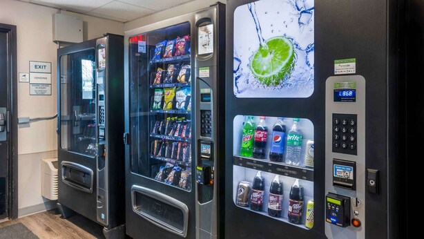 Three self-service beverage vending machines with a digital display, a keypad, and a card reader. - Extended Stay America Select Suites - Springfield - South - Battlefield (Springfield)