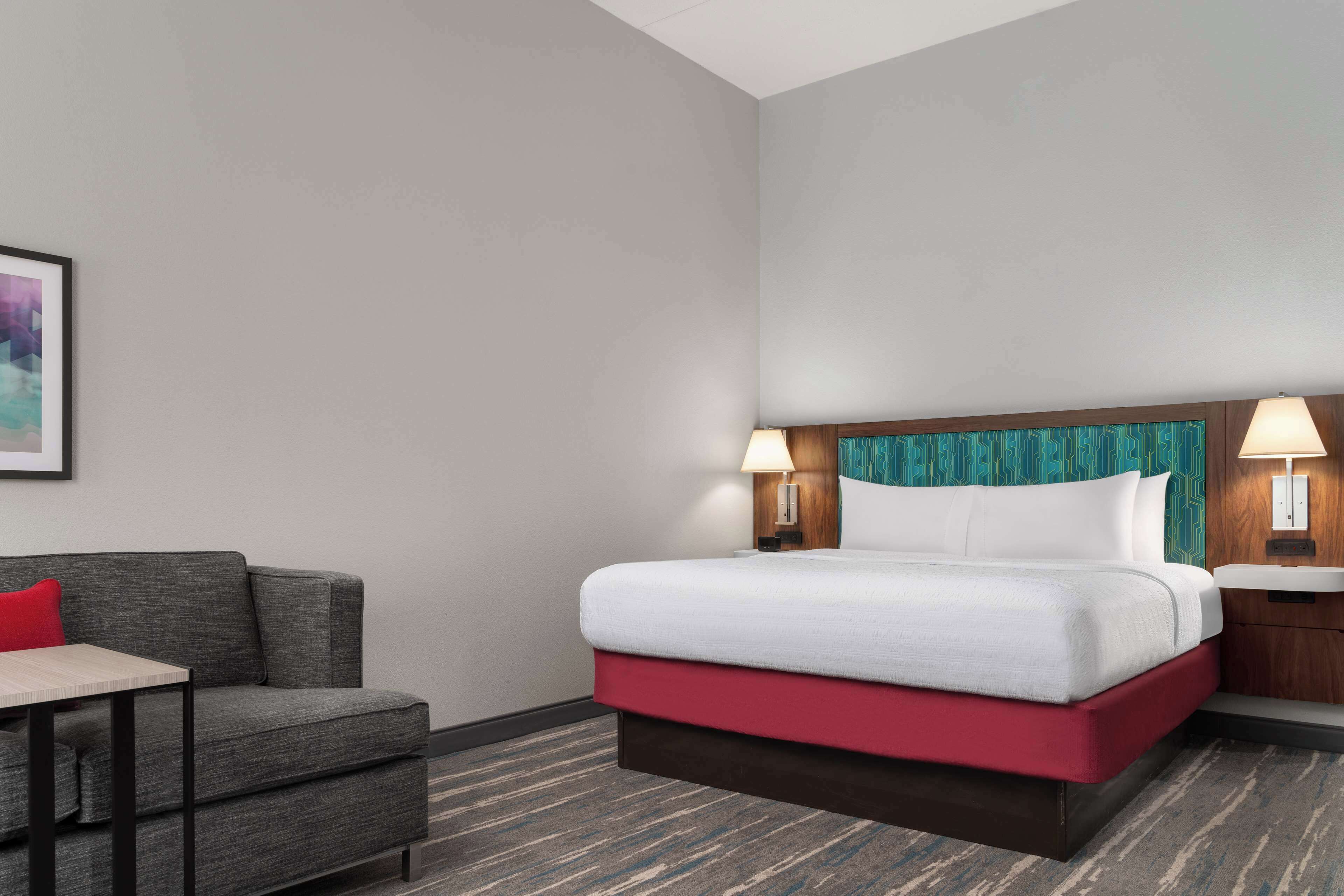 Una habitación de hotel con una cama, un escritorio y una silla.