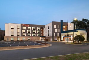 A Hampton Inn by Hilton hotel with a parking lot and a landscaped area.