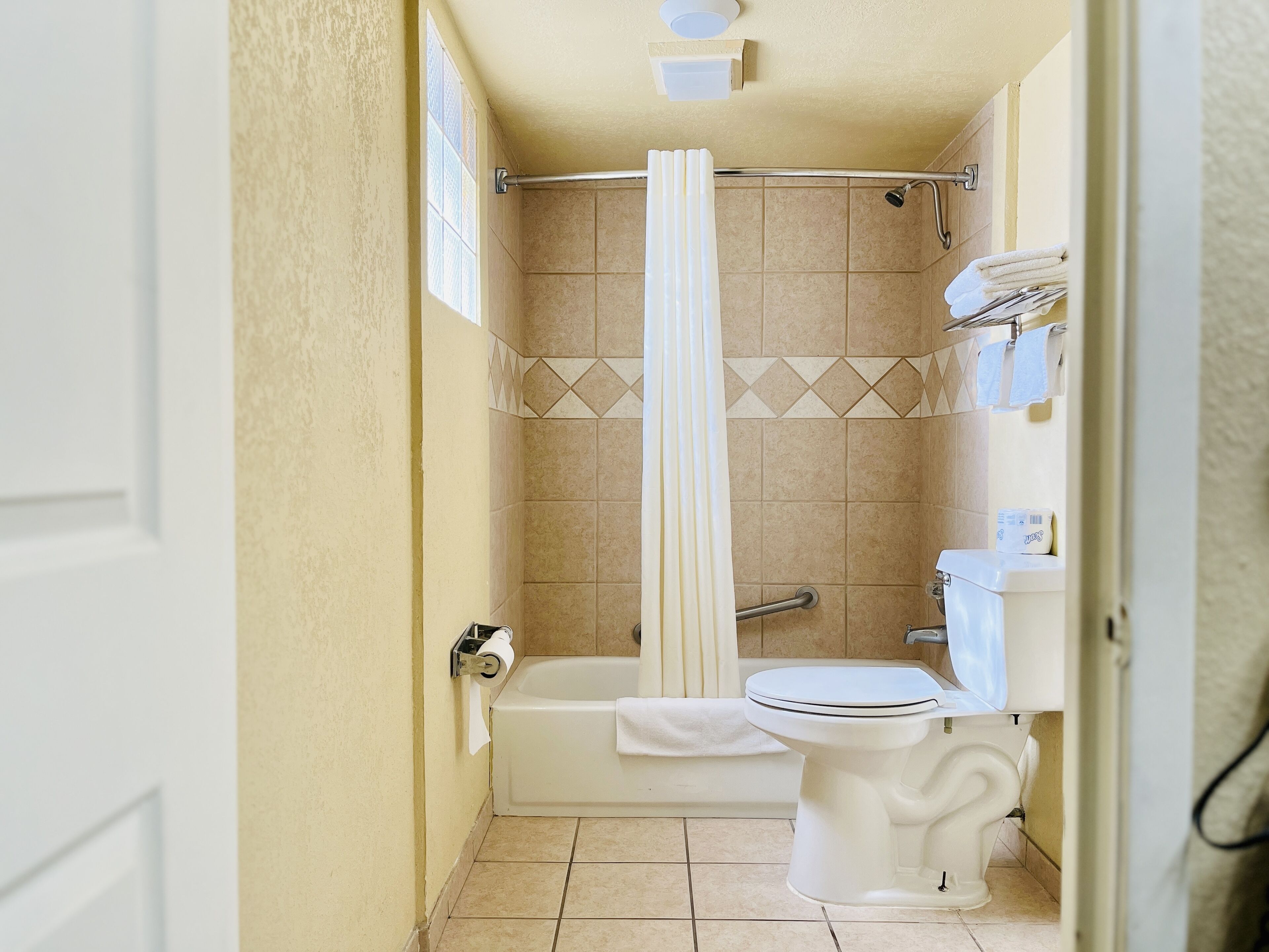 Un baño pequeño con bañera, inodoro y ducha.