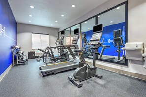 A modern gym with treadmills, elliptical machines, and stationary bikes.