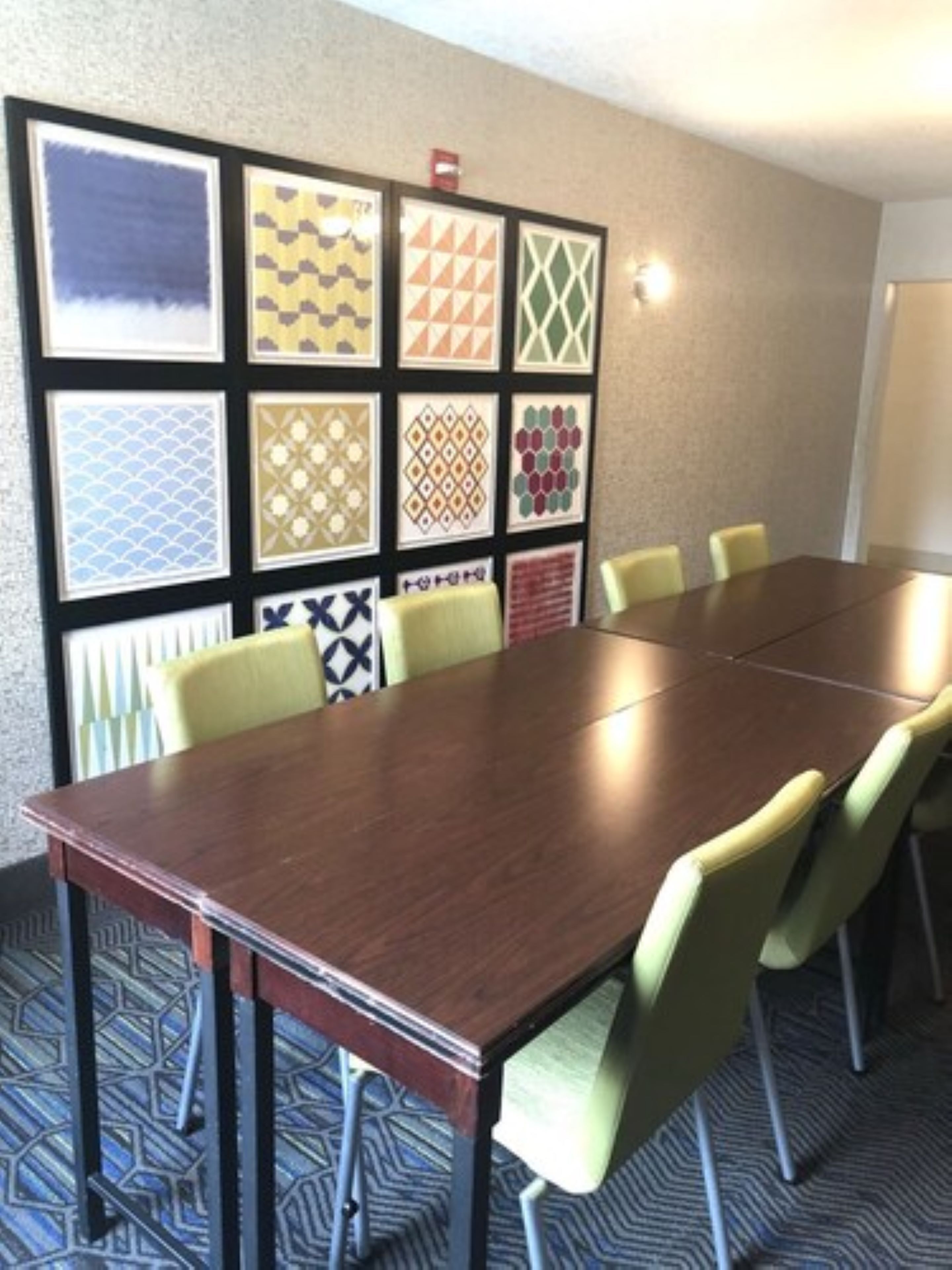 Un salón de conferencias con una mesa larga y seis sillas.