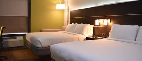 Une chambre d’hôtel avec deux lits, un bureau et une chaise.