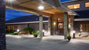 A hotel entrance with stone pillars, a covered walkway, and a well-lit facade. - AmericInn by Wyndham Thief River Falls (Thief River Falls)