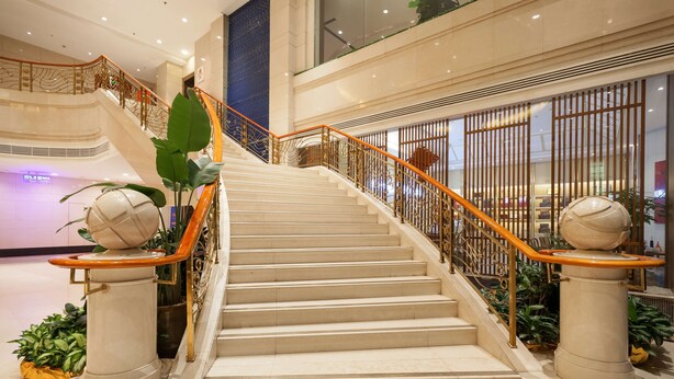 A marble staircase with golden railings and decorative columns, leading to an upper level in a modern building. - Best Western Plus Fuzhou Fortune Hotel (Fuzhou)