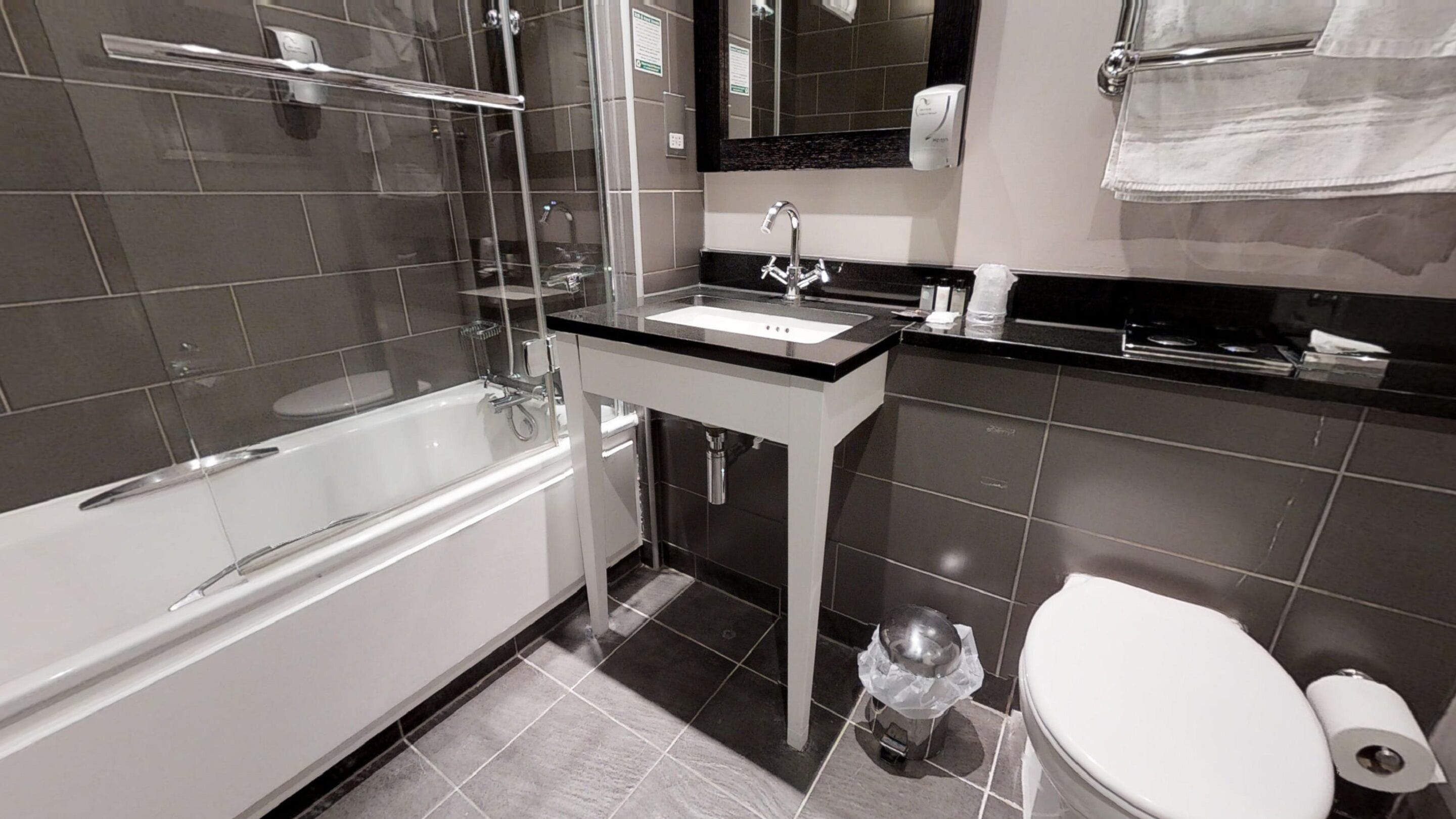 Ein modernes Badezimmer mit Badewanne, Waschbecken und Toilette.