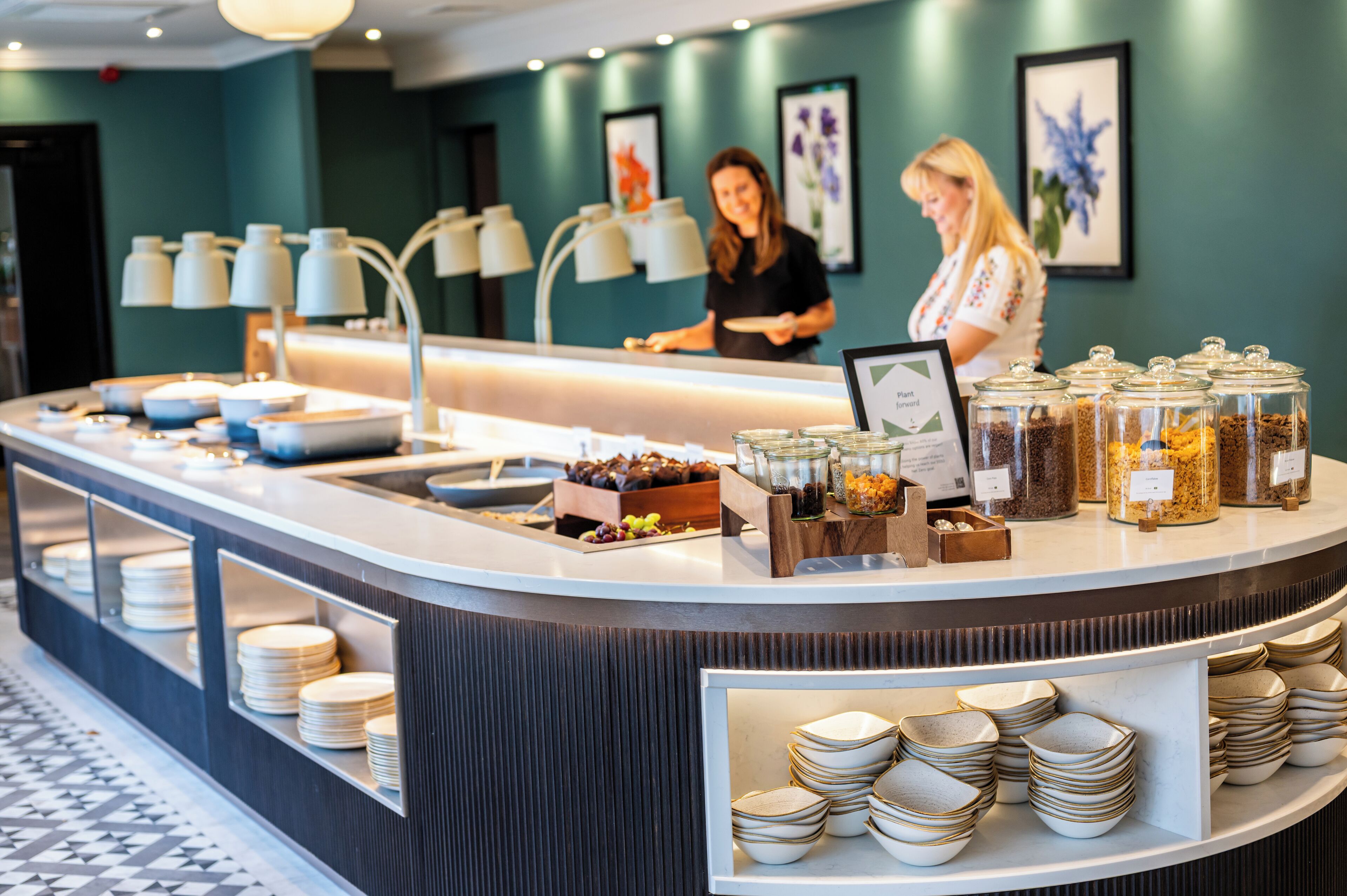 A buffet area with various food items and a counter where staff are serving.
