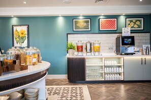A breakfast bar with a variety of food items, a coffee machine, and a juice dispenser. - Milton Hill (Abingdon)