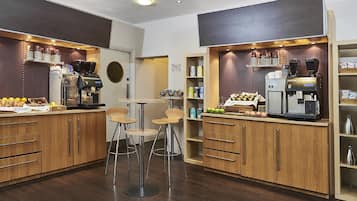 Een moderne koffiebar met twee espresso machines, houten kasten en barstoelen.