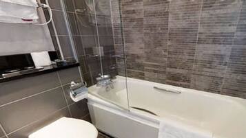 A modern bathroom with a glass-enclosed shower, a white bathtub, and a toilet.