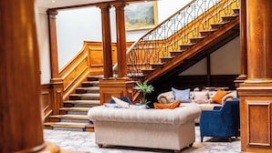 A grand staircase with wooden railings and columns, leading to an upper floor. - Milton Hill (Abingdon)