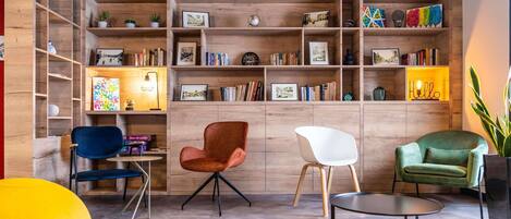 Un interior moderno con estanterías de madera, libros y tres sillas.