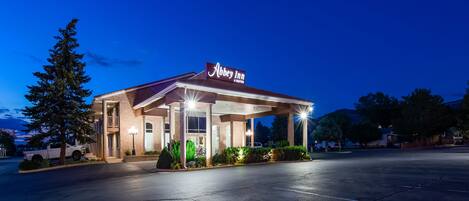 Un hôtel doté d’un espace extérieur abrité, d’une enseigne indiquant « Abbey Inn » et d’un parking.